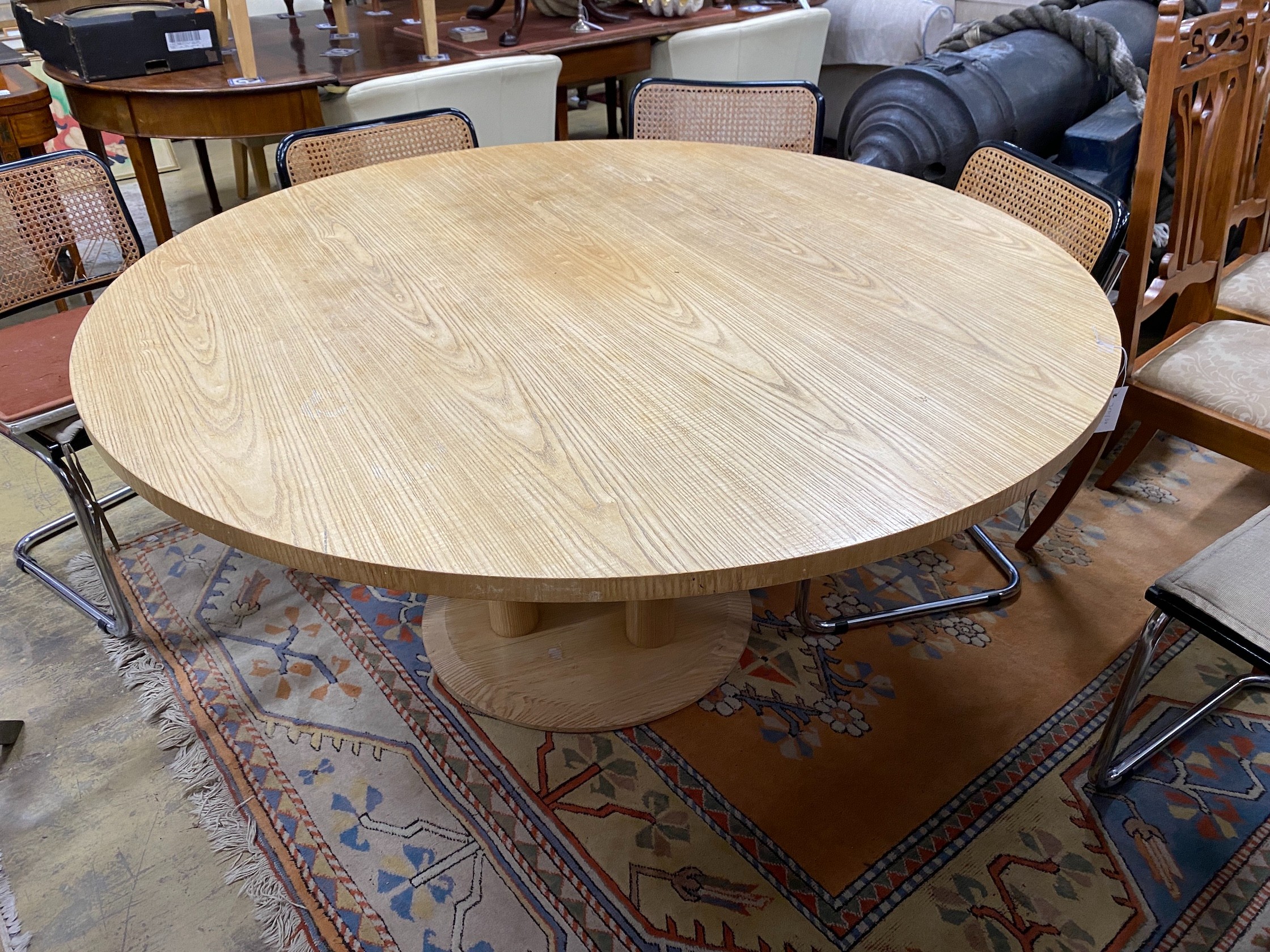 A Conran retailed circular pale ash dining table, on three pillars and circular plinth foot, diameter 150cm, height 73cm